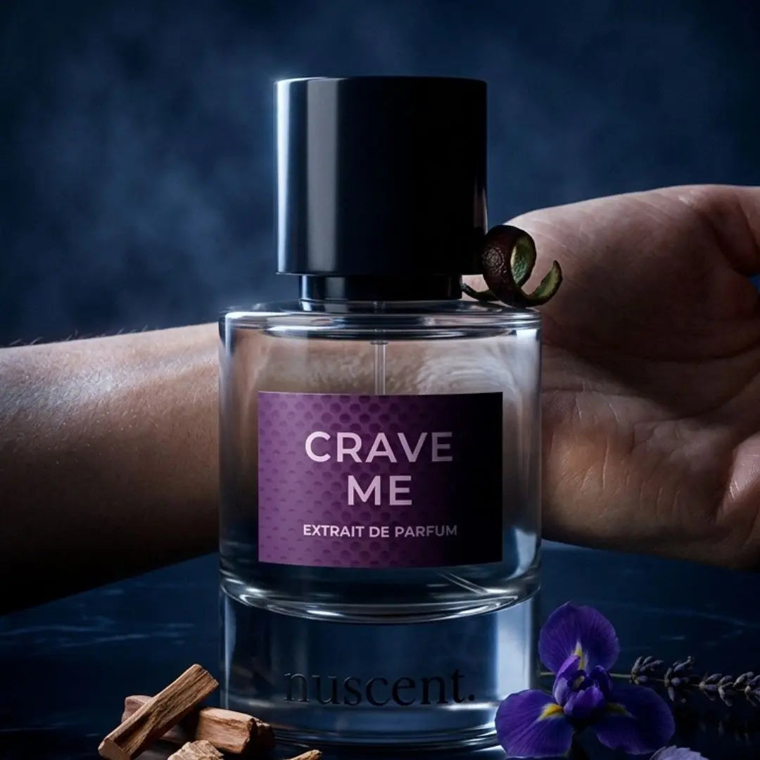 Hand holding and spraying Crave Me Extrait de Parfum fragrance with lavender and ginger ingredients visible