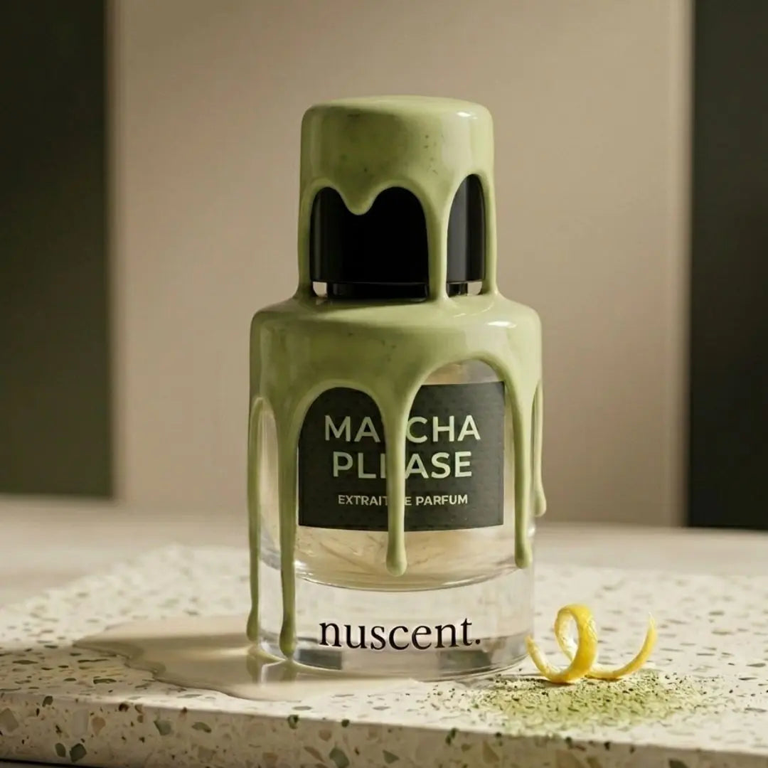 Matcha Please Extrait de Parfum with artistic matcha powder dripping from cap with lemon zest and fresh matcha powder scattered on light surface