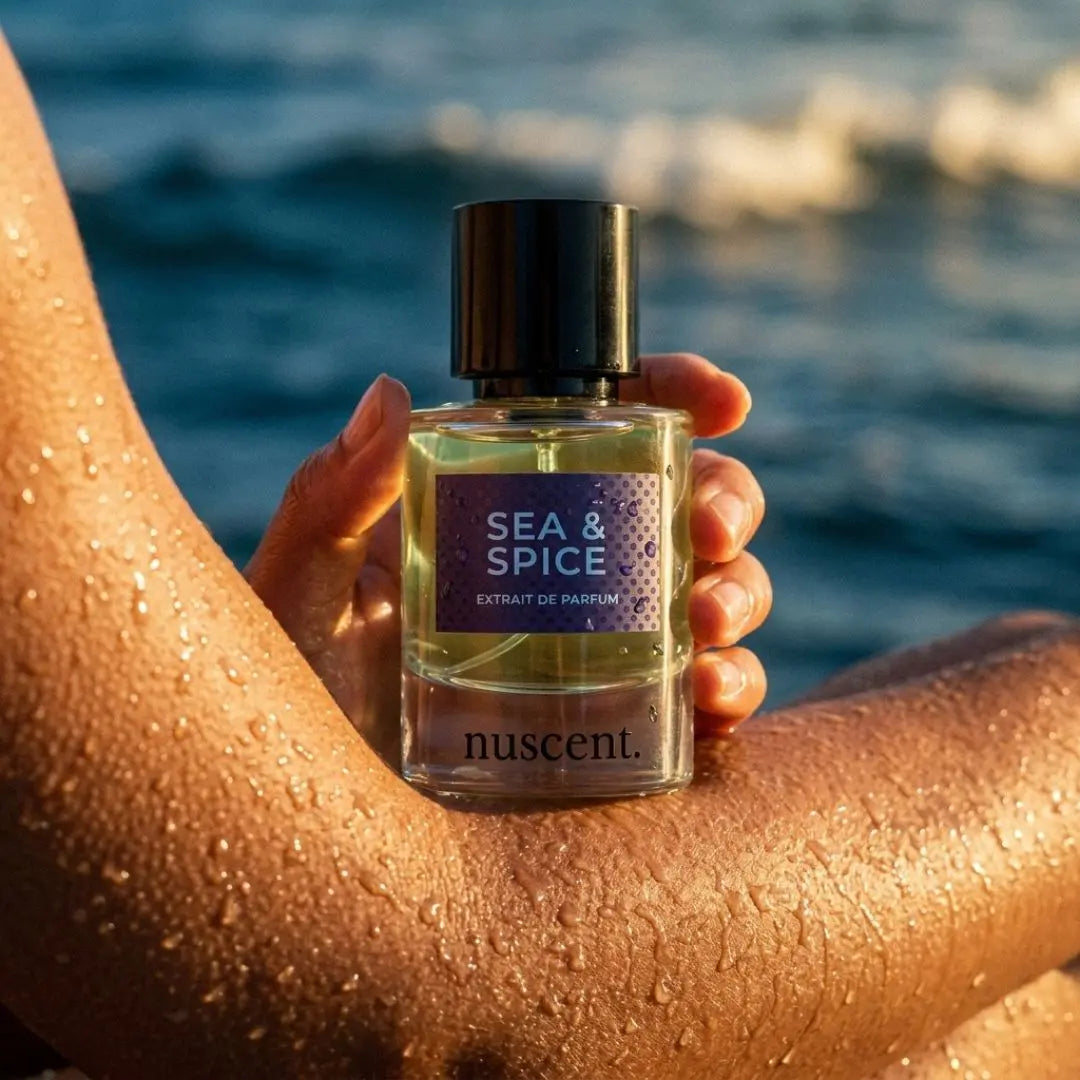 Sea & Spice nuscent fragrance held in hand on beach with ocean backdrop — fresh marine perfume for coastal moments